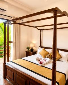 a bedroom with a canopy bed in a room at River Bay Hotel in Pillagoda
