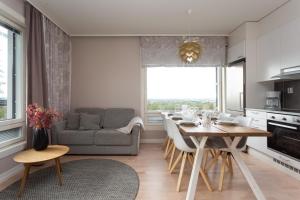 a kitchen and living room with a table and a couch at Santasport Apartment Hotel in Rovaniemi