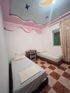 a bedroom with two beds and a ceiling with stars at maison avec jardin in Cabo Negro