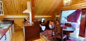 a kitchen and living room in a log cabin at iNKiLAS KLIUKAI in Bijutiškis