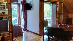 a living room with a dining room table and large windows at iNKiLAS KLIUKAI in Bijutiškis