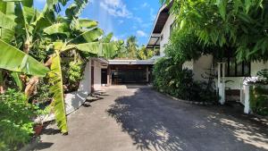 a courtyard of a house with trees and a driveway at SCO Lodge in Punaauia
