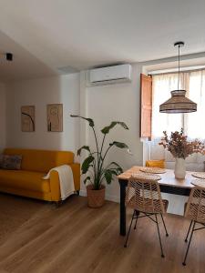 a living room with a yellow couch and a table at Erreka Etxea in Murueta-Orozko