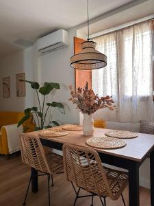 a dining room table with chairs and a vase with flowers at Erreka Etxea in Murueta-Orozko