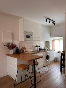 a kitchen with white cabinets and a wooden counter top at Erreka Etxea in Murueta-Orozko +1 photo