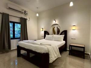 a bedroom with a large bed and a mirror at Village Sunset Paradise Beach Resort in Morjim +70 photos