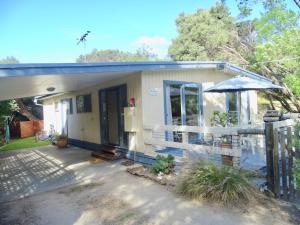 a small house with a fence in front of it at Beachwalk Cottage in Sorrento