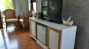 a living room with a flat screen tv on a white cabinet at Gin's Greenery Resort in Ban Hua Wiang +56 photos