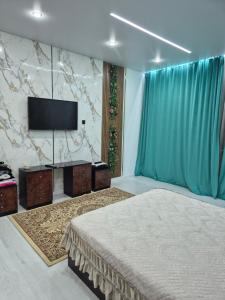 a bedroom with a bed and a flat screen tv at На Желтоксан in Taldykorgan +33 photos