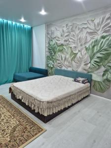 a bedroom with a bed and a wall with a mural at На Желтоксан in Taldykorgan