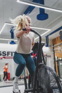 a woman sitting on a bike in a gym at Santasport Apartment Hotel in Rovaniemi