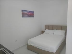 a bedroom with a bed with white sheets and pillows at Taku Rooms Vlora 2 in Vlorë