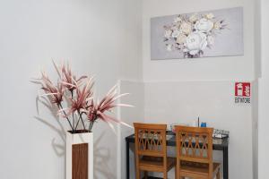 a dining room with a table and a vase with flowers at Tre Corone - Sarno in Sarno
