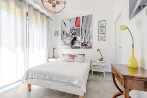 a white bedroom with a bed and a desk at Villa Npda in Carpentras
