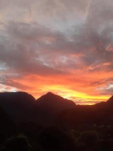 a sunset over a mountain range with the sun setting at Dortoirs in La Possession