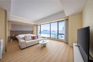 a living room with a white couch and a tv at 栖雅民宿 in Beijing