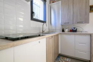 a kitchen with white cabinets and a sink at Villa Npda in Carpentras +20 photos