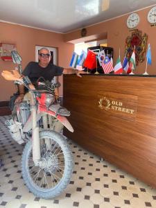 a man sitting at a counter with a motorcycle at OLD STREET Guest House in Samarkand