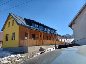 a yellow house with a deck on top of it at Turistický apartmánový domček Runina 11 in Runina