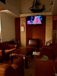 a living room with couches and a flat screen tv at Hotel Berlina in La Paz