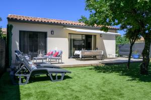 a yard with chairs and a table and a house at Villa Npda in Carpentras