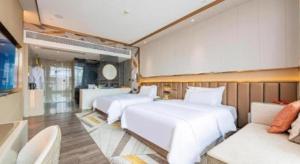 a bedroom with two white beds and a couch at Tomeet Hotel in Meizhou +57 photos
