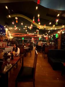 a woman sitting at a table in a restaurant at night at Hotel Berlina in La Paz