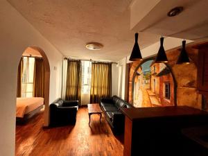 a hotel room with a bed and a couch and a table at Hotel Berlina in La Paz
