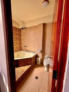 a bathroom with a bath tub and a toilet at Hotel Berlina in La Paz +25 photos