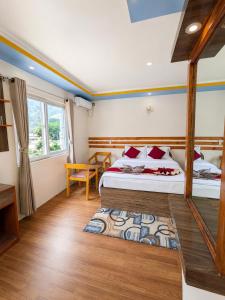 a bedroom with a bed and a table and a window at Sukute River Hub Beach Resort in Dolālghāt