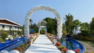 an arch over a pool at a resort with flowers at Churinga Eco Resort in Tigaon