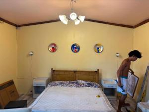 a boy in a bedroom with a bed and plates on the wall at Churinga Eco Resort in Tigaon
