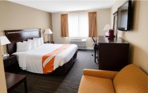 a hotel room with a large bed and a chair at Remembrance Inn Gettysburg in Gettysburg
