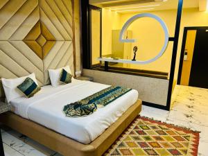 a bedroom with a large bed with a mirror at The Hotel Emerald in Koraput