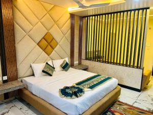 a bed in a room with a large window at The Hotel Emerald in Koraput