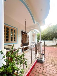a porch of a house with a swing at Aamra Ghar by evaddo stays in Mandrem