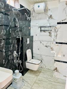 a bathroom with a toilet and a sink at The Hotel Emerald in Koraput