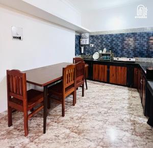 a kitchen with a wooden table and chairs at Aamra Ghar by evaddo stays in Mandrem