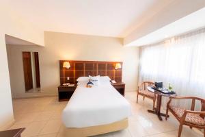 a bedroom with a large white bed and a desk at Hotel Faranda Express Soloy and Casino, a member of Radisson Individuals in Panama City