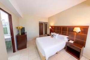 a hotel room with a large white bed and a window at Hotel Faranda Express Soloy and Casino, a member of Radisson Individuals in Panama City