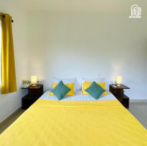 a bedroom with a bed with yellow and green pillows at Aamra Ghar by evaddo stays in Mandrem +51 photos