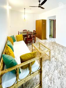 a bedroom with a bed with yellow and green pillows at Aamra Ghar by evaddo stays in Mandrem