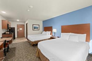 a hotel room with two beds and a desk at MainStay Suites Spokane Valley in Spokane Valley