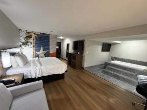 a hotel room with a bed and a bath tub at Clarion Pointe Addison - Dallas North in Addison