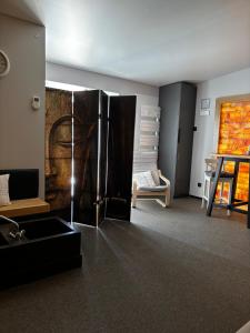 a living room with a refrigerator and a couch at Relax Trois Bornes - De Grenspost in Gemmenich