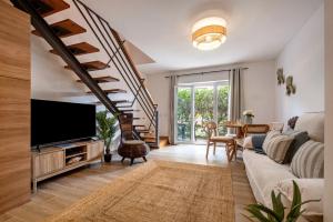 a living room with a couch and a tv at Cabanas Gardens by MY CHOICE in Cabanas de Tavira