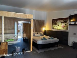 a bedroom with a bed and a painting on the wall at Relax Trois Bornes - De Grenspost in Gemmenich