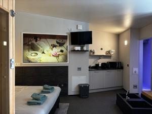 a room with a kitchen and a bed with towels at Relax Trois Bornes - De Grenspost in Gemmenich