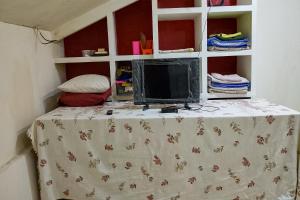 a tv sitting on top of a table in a room at RedDoorz at Jatisampurna 