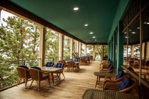 a balcony with tables and chairs and windows at Kobuleti Georgia Palace Hotel & Spa in Kobuleti